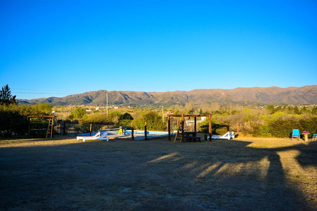 un parque con un parque infantil con montañas al fondo en Turismo Aparts Cabaña 3 Monoambiente, en Villa Giardino