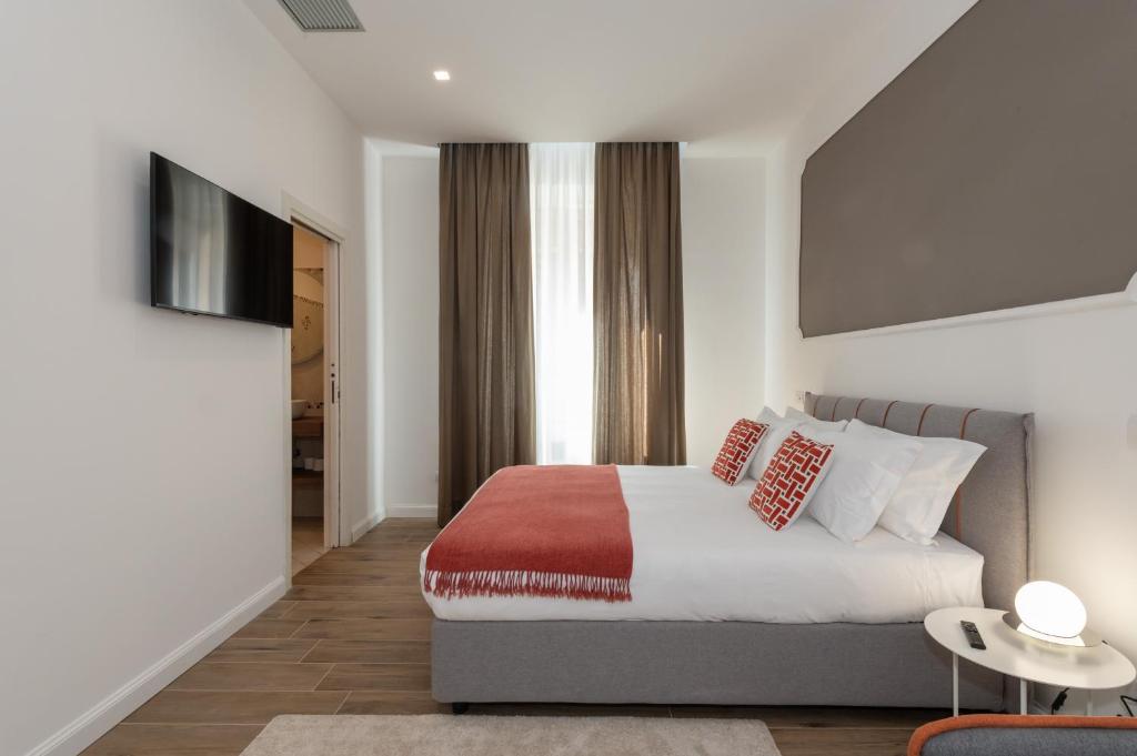 una camera da letto con un letto e una televisione di Nox a Roma