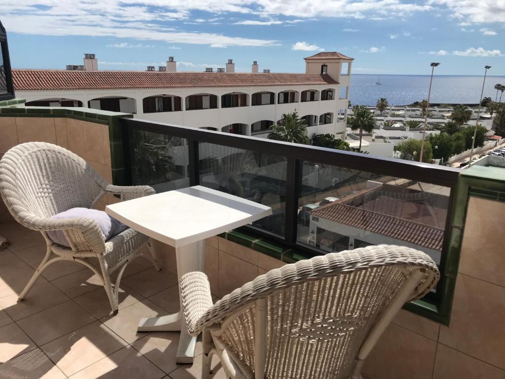 Un balcón con sillas y una mesa y vista al mar. en Atlantic sunset studio, en Costa del Silencio
