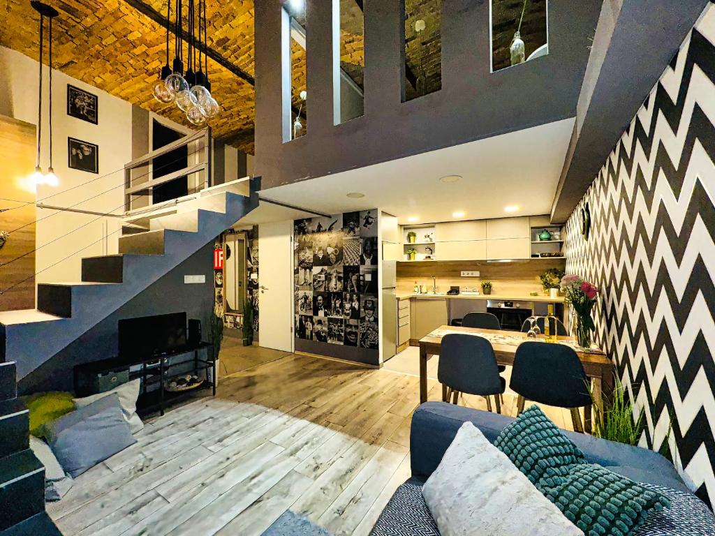 a living room with a blue couch and a staircase at Csengery Apartment in Budapest