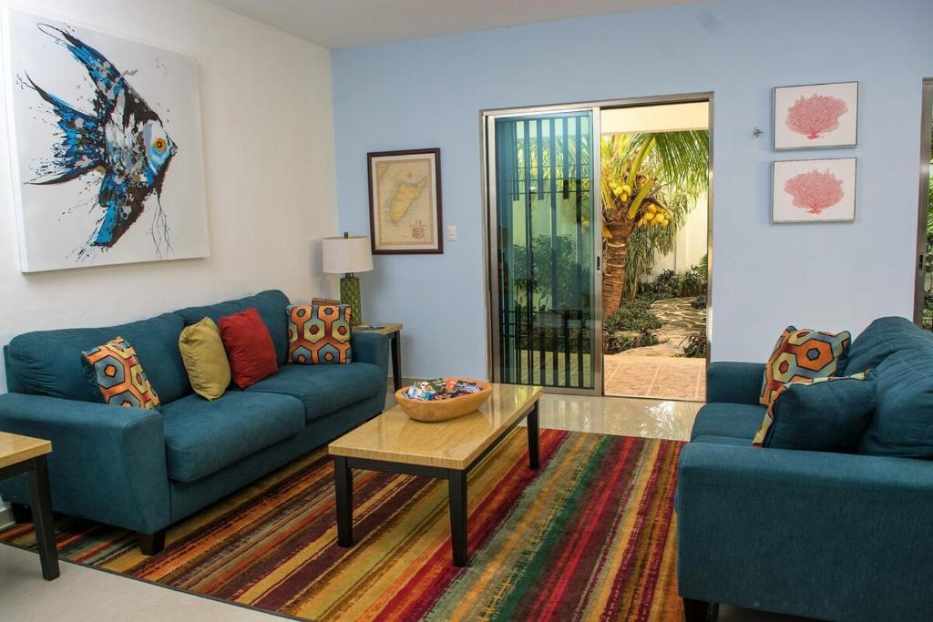 ein Wohnzimmer mit zwei blauen Sofas und einem Tisch in der Unterkunft Casa de Mario 4 Beautiful house with a huge pool in Cozumel
