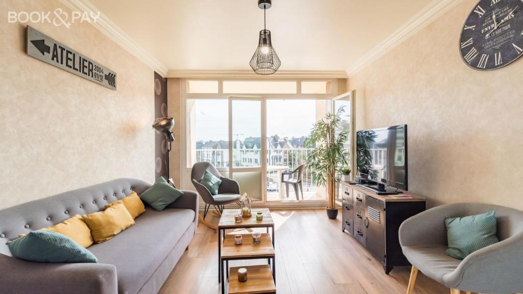a living room with a couch and a tv at L'escapade bretonne in Saint-Brieuc