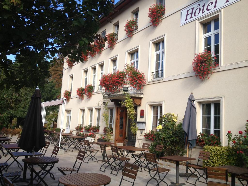 a hotel with tables and chairs in front of it at Le Clos De Mutigny in La Chaussée-sur-Marne