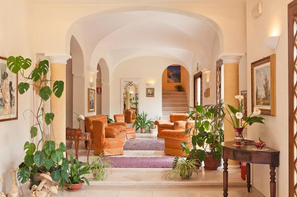 a living room filled with furniture and lots of plants at Torre Bennistra in Scopello