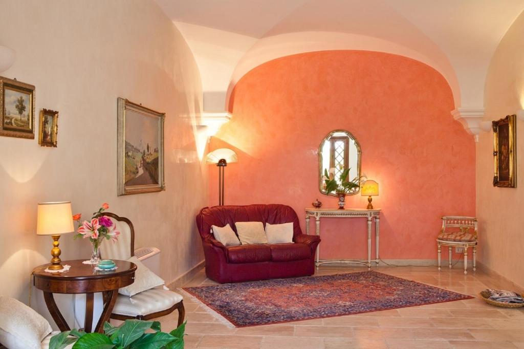a living room with a red chair and a table at Torre Bennistra in Scopello
