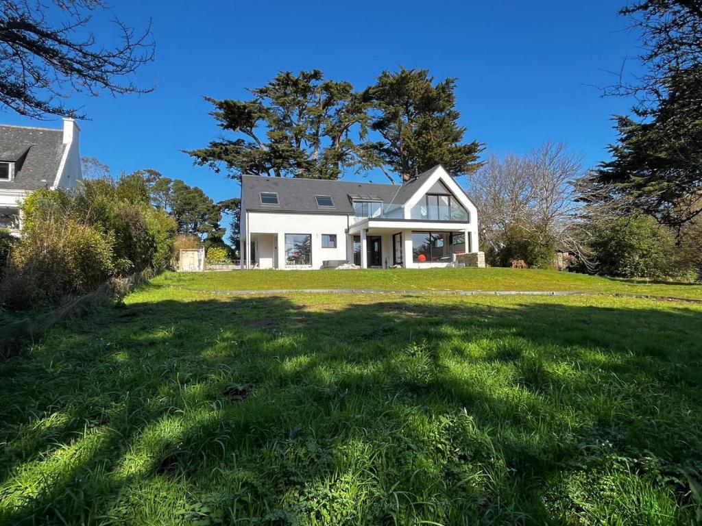 une maison blanche avec une grande pelouse dans l'établissement Votre parenthèse enchantée dans Ty Nids d'Amour, à Névez