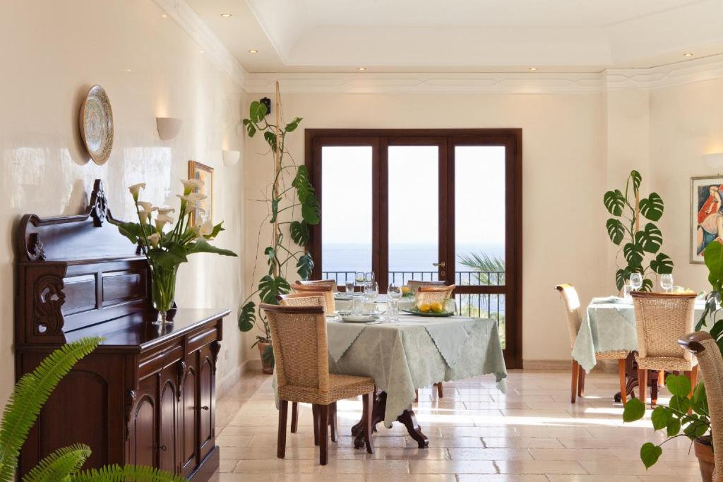 a dining room with a table and a balcony at Torre Bennistra in Scopello