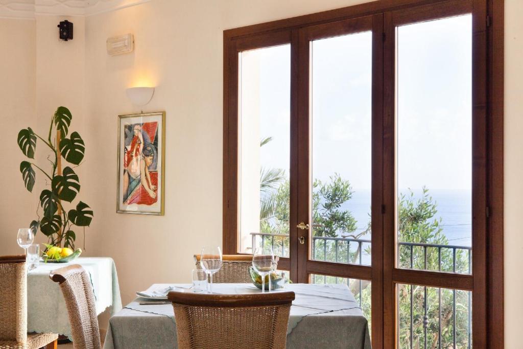 a dining room with a table and a glass door at Torre Bennistra in Scopello