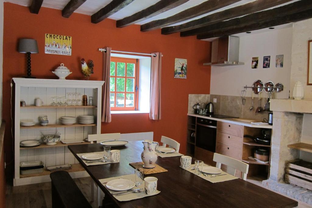 une cuisine avec une table en bois et une salle à manger dans l'établissement L'Allée - Maison d'hôtes - Charme - Digital detox, à Vernantes