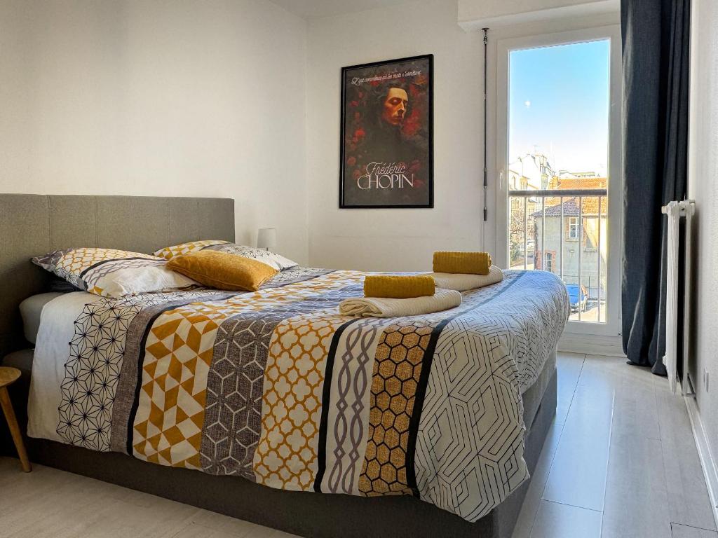 sypialnia z łóżkiem z plakatem na ścianie w obiekcie Appartement Chopin au coeur de Nancy w Nancy