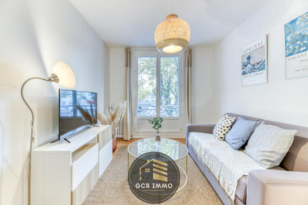 un salon avec un canapé et une télévision dans l'établissement Le Balzac - T2 Cosy proche centre ville - Stationnement gratuit, à Grenoble