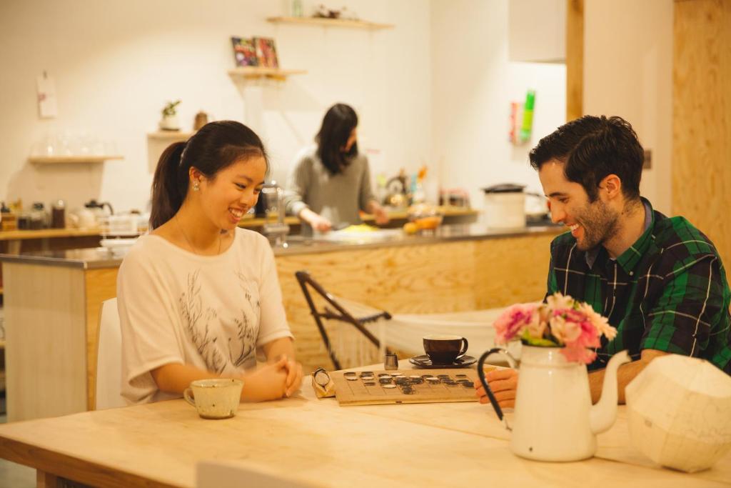 a man and a woman sitting at a table at Guest House MARUYA in Atami