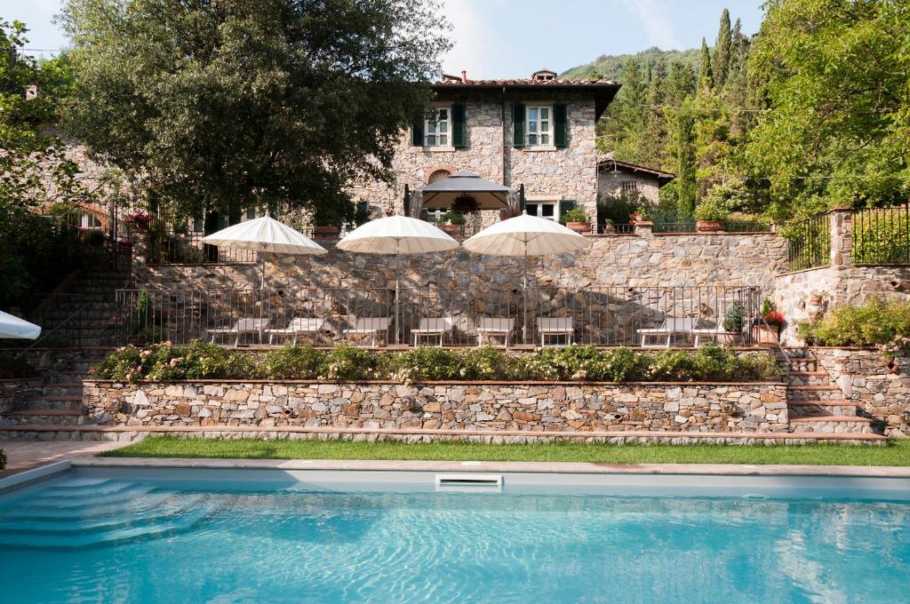 una casa con piscina y sombrillas en Relais Victoria B&B, en San Macario In Piano