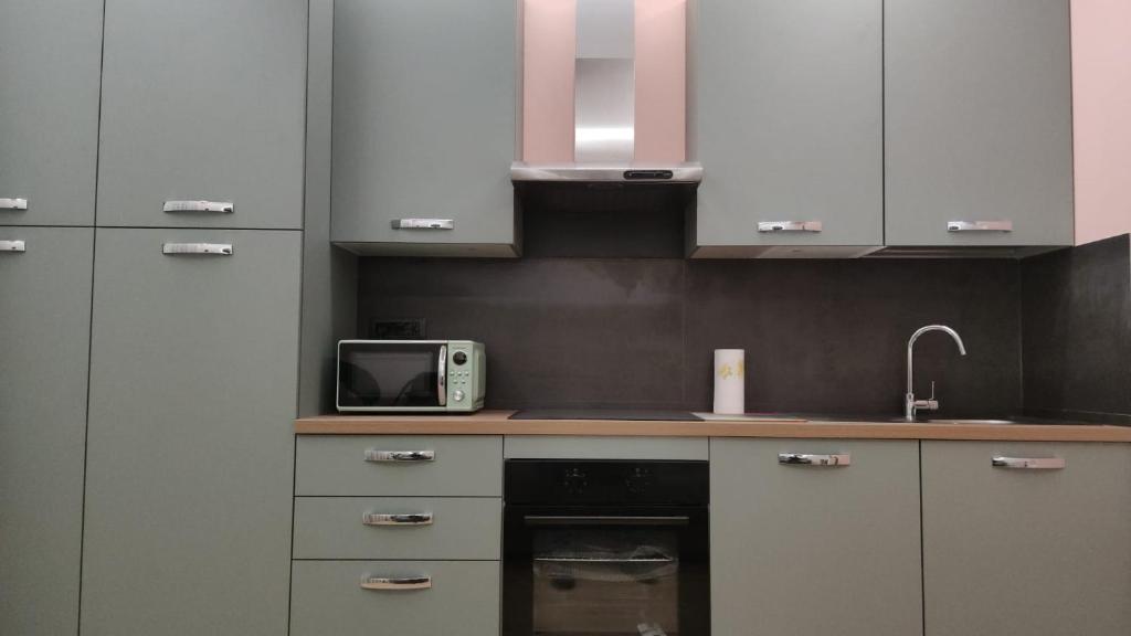 a kitchen with white cabinets and a microwave at Albert house in La Pescaia