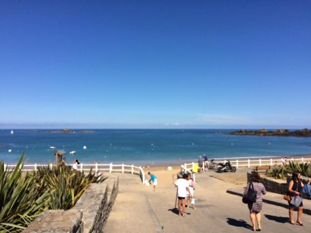 un groupe de personnes marchant sur la plage dans l'établissement Les pieds dans l'eau, à Saint-Malo