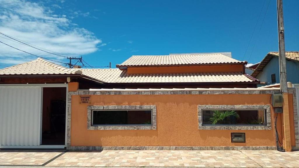 a house with two windows and a roof at Casa com piscina em Cabo Frio Unamar in Cabo Frio