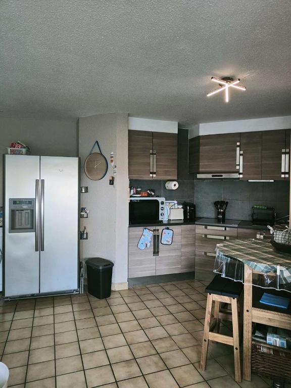 Il comprend une cuisine équipée d'un réfrigérateur blanc. dans l'établissement Résidence Caraibes - Appartement 3 pièces climatisé, avec accès WIFI à LE BARCARES - CAP COUDALERE MAE-8051, au Barcarès