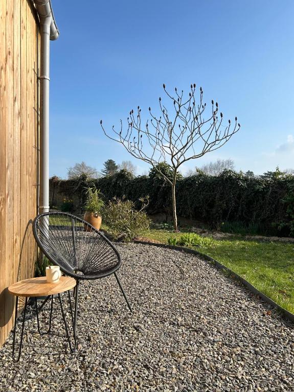 une chaise et une table sur une terrasse en gravier dans l'établissement La Cabane, à Quiberville