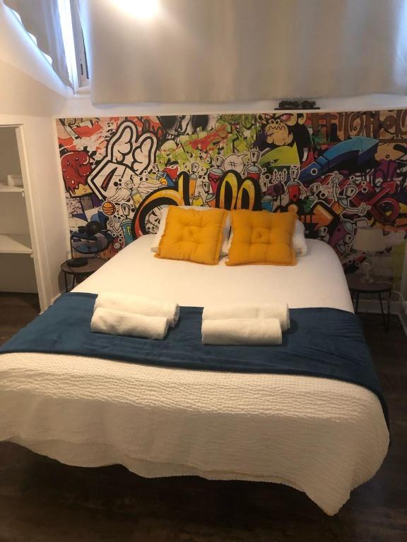 Una cama con almohadas amarillas y una pared con graffiti. en richman studio style, en Rabat