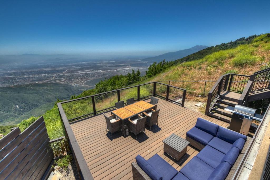 a deck with a table and chairs on top of a hill at Lake Gregory Skyline Ridge in Crestline