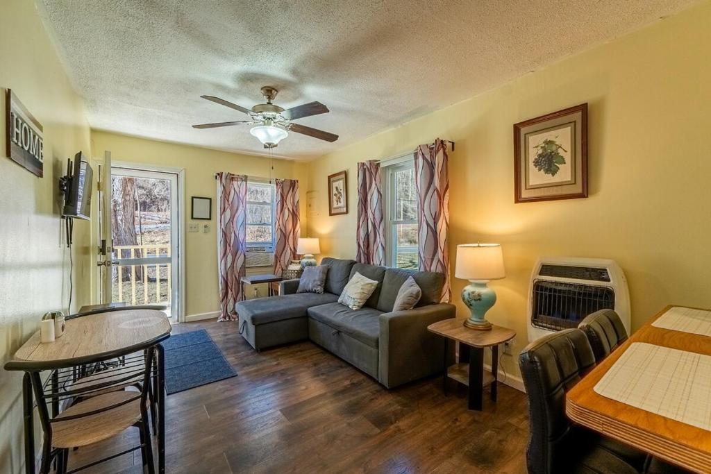 a living room with a couch and a table at Quaint Cabin By The Creek Private in Pipestem