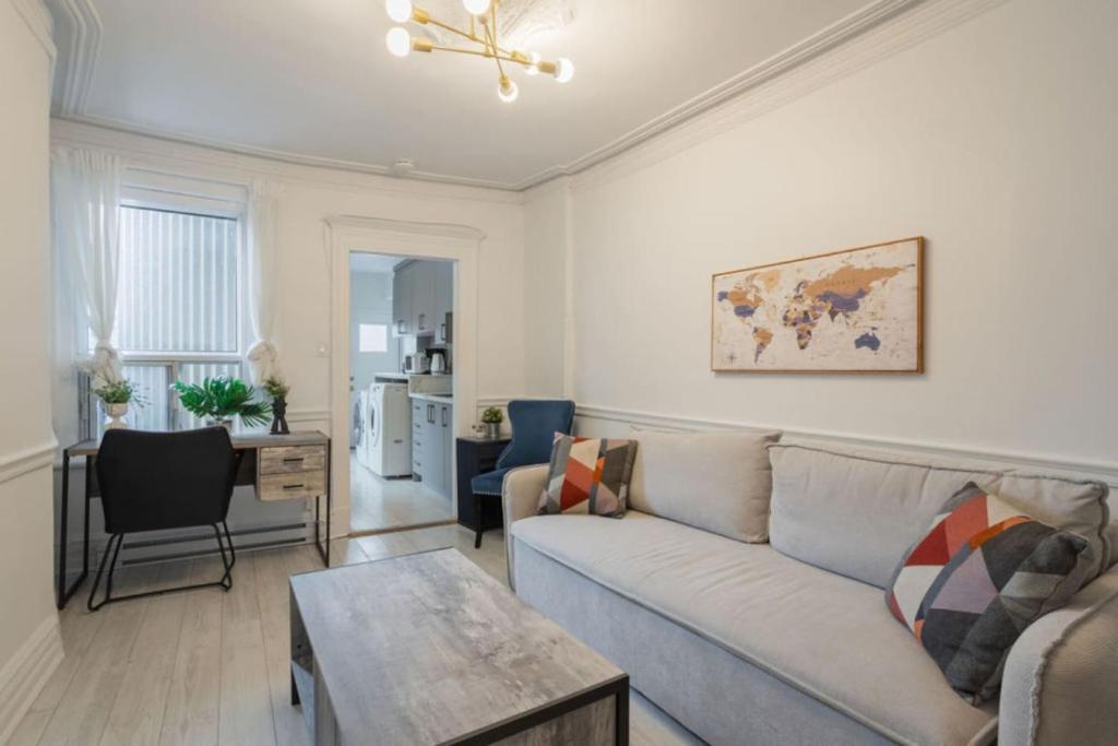 una sala de estar con un sofá y una mesa en Grand Urban 4BR Luxe Loft in Griffintown, en Montreal