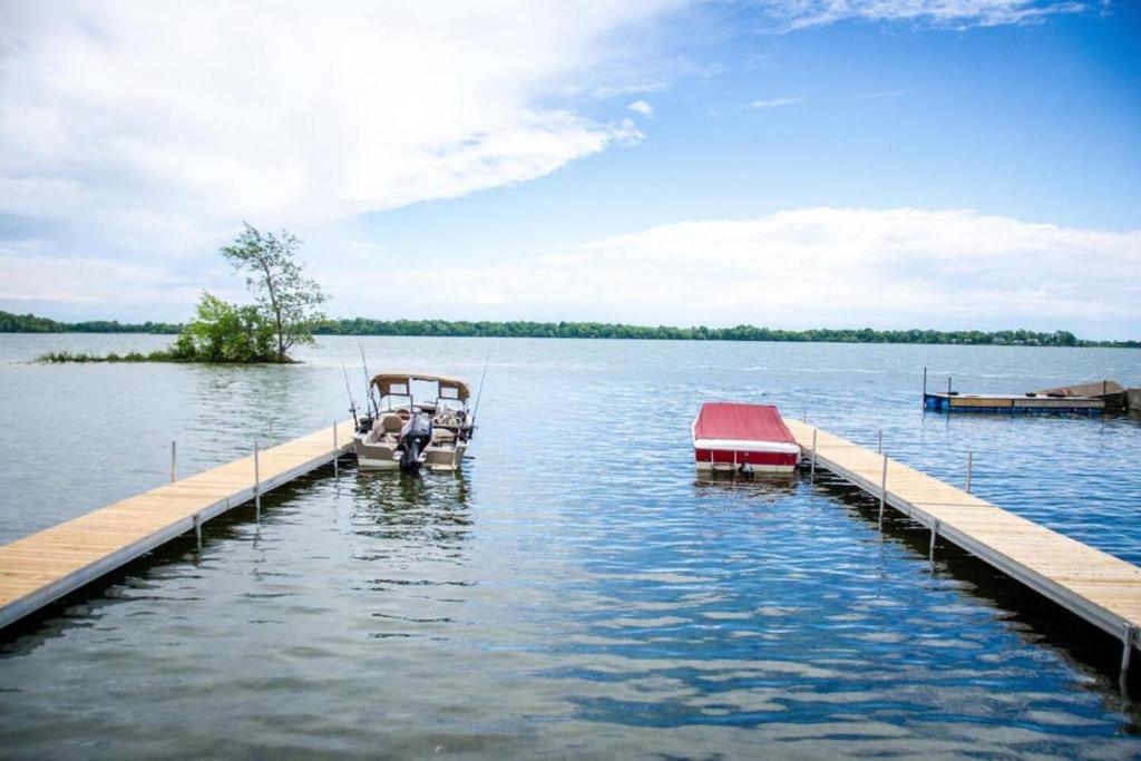 twee boten zijn aangemeerd op een dok op een meer bij Westlake Consecon Cottage in Wellington
