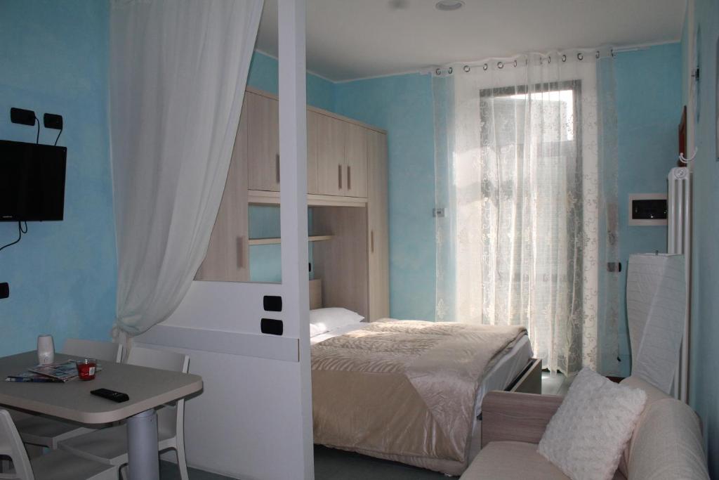 a bedroom with a bed and a desk and a table at Residenza acqua terra fuoco in Como