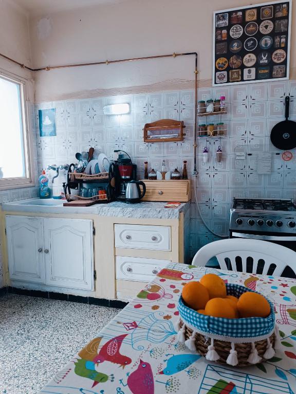 a kitchen with a table with a bowl of oranges on it at Dar Hkaïem in Sousse
