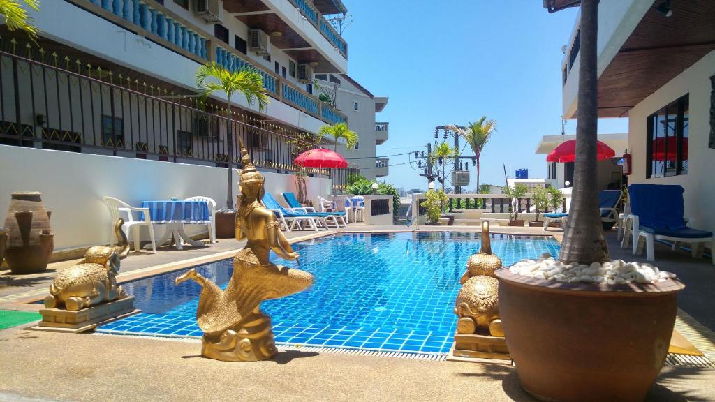 a swimming pool with gold statues next to a building at Blue Sky Residence in Patong Beach