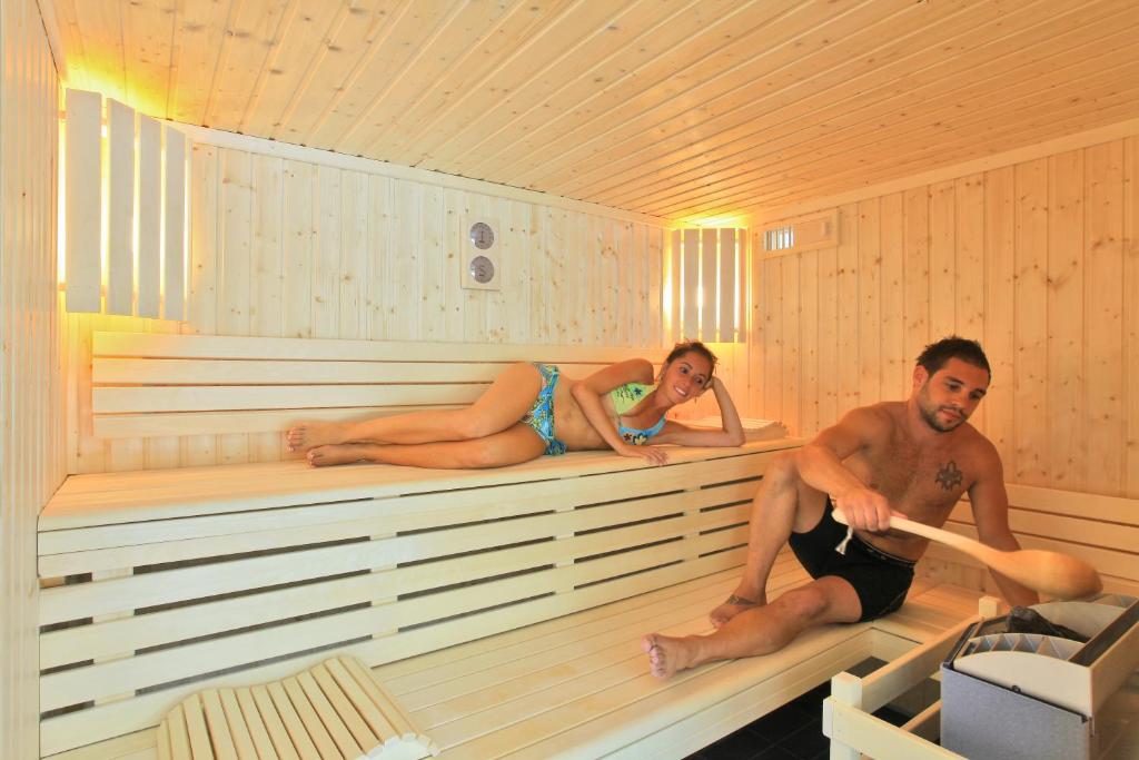 two people are sitting in a sauna at Albirondack Camping Lodge &amp; Spa in Albi