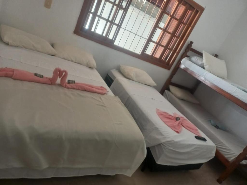 a bedroom with two beds with dolls on them at Pousada Milionário in Guarujá