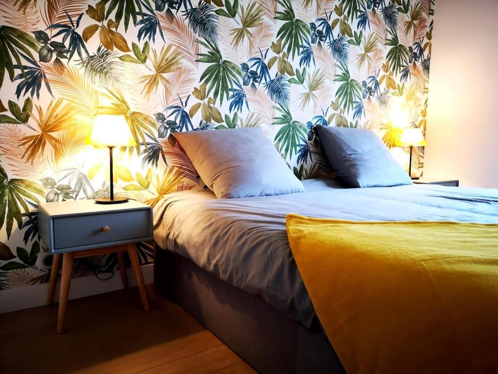 une chambre avec un lit avec un papier peint tropical dans l'établissement Appartement Juan Les Pins à 700 m des plages, à Antibes