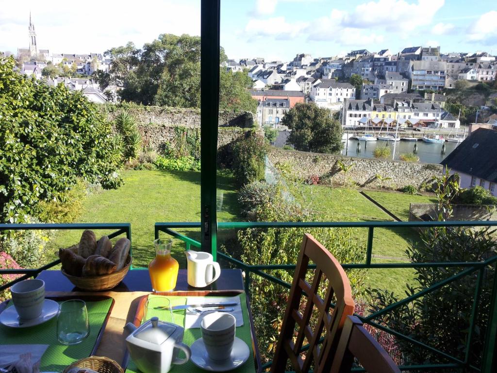 a table with a view of a city from a balcony at Cit'Hotel Du Port Rhu in Douarnenez
