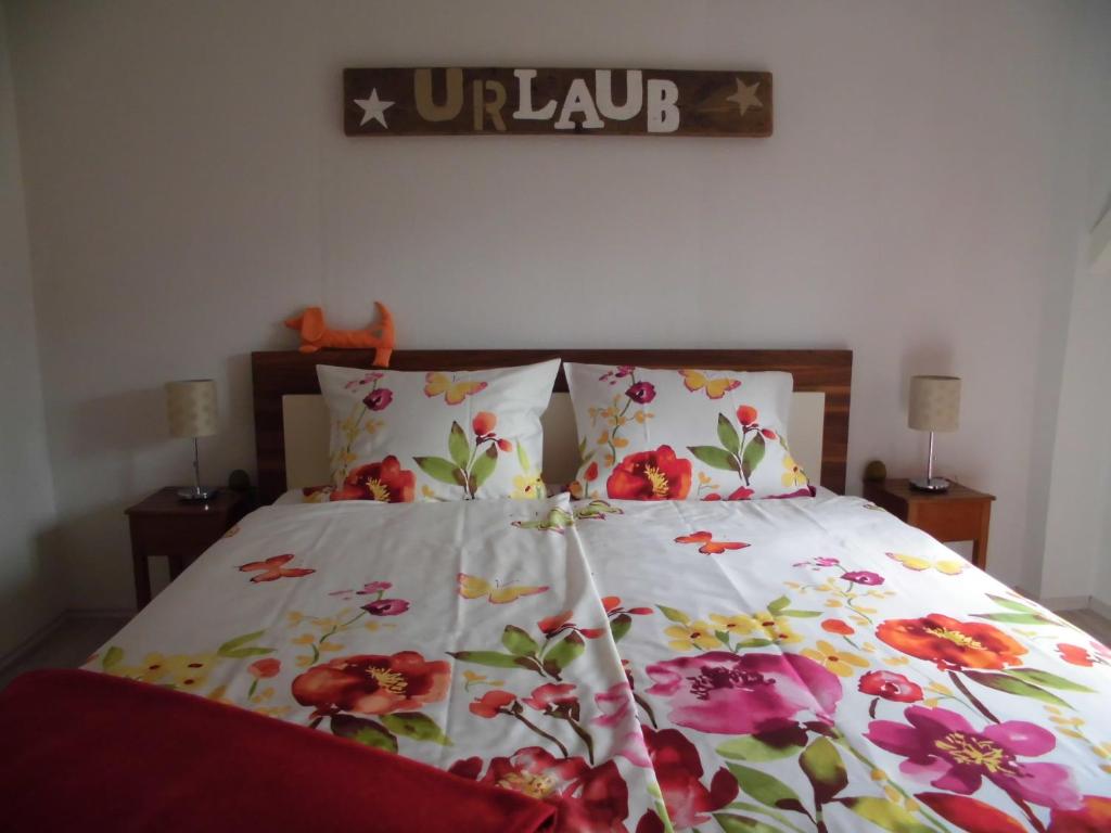 a bed with a floral comforter and two pillows at Apartments Schnepel in Sankt Michaelisdonn