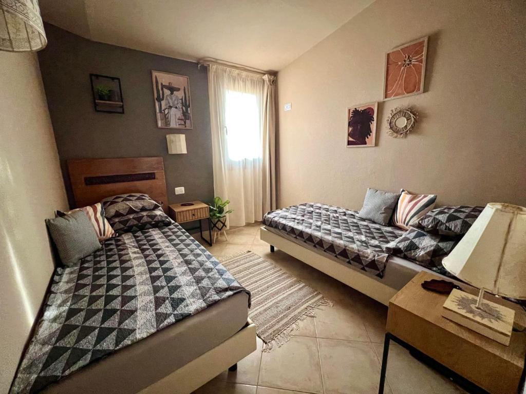a bedroom with two beds and a table with a lamp at Tropical Morna in Santa Maria
