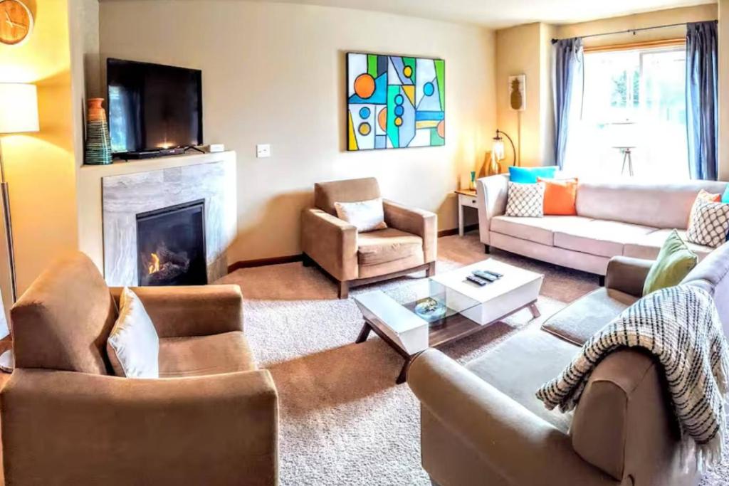 a living room with couches and a fireplace at Seaside Serenity. in Seaside