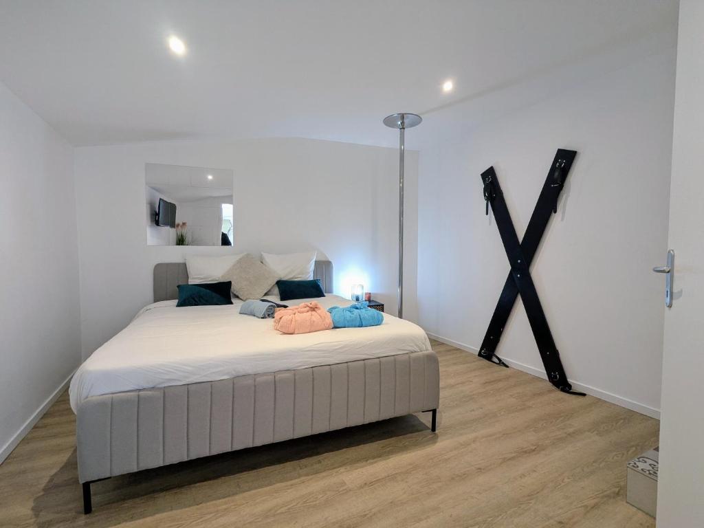 une chambre avec un grand lit blanc dans une pièce dans l'établissement Plaisir et passion, à Roanne