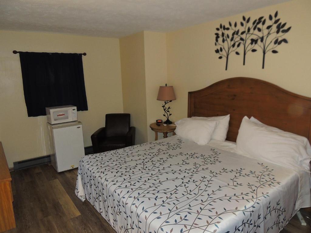 a bedroom with a bed with a black and white comforter at White Caps Motel in Port Clinton