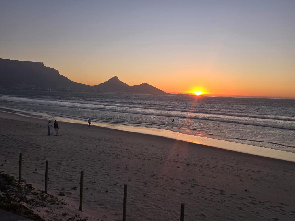 开普敦Sunset at Keys的海滩上的日落,人们在海滩上散步