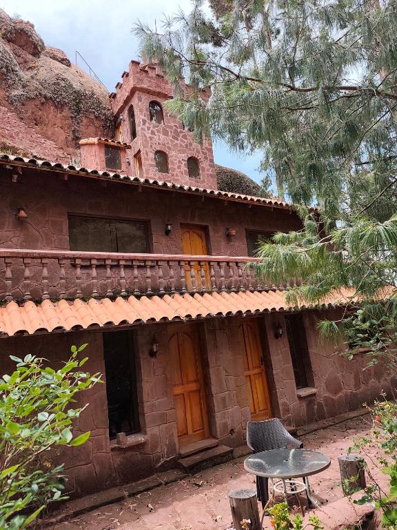 an old house with a table in front of it at Posadas del Castillo del Titicaca in Vencalla