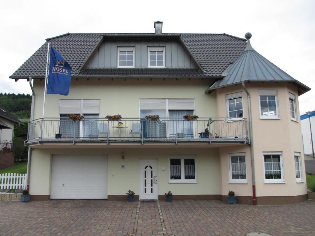 ブリーデルにあるWeingut u. Gästehaus Mentenのバルコニー付きの家