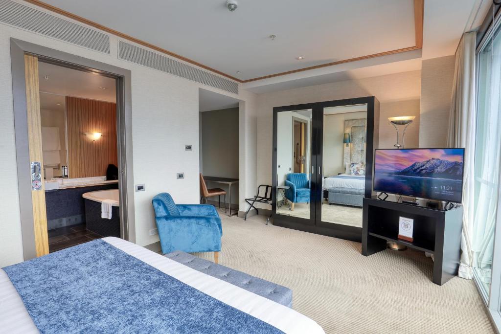 a hotel room with a bed and a tv and a bedroom at Marsden Viaduct in Auckland