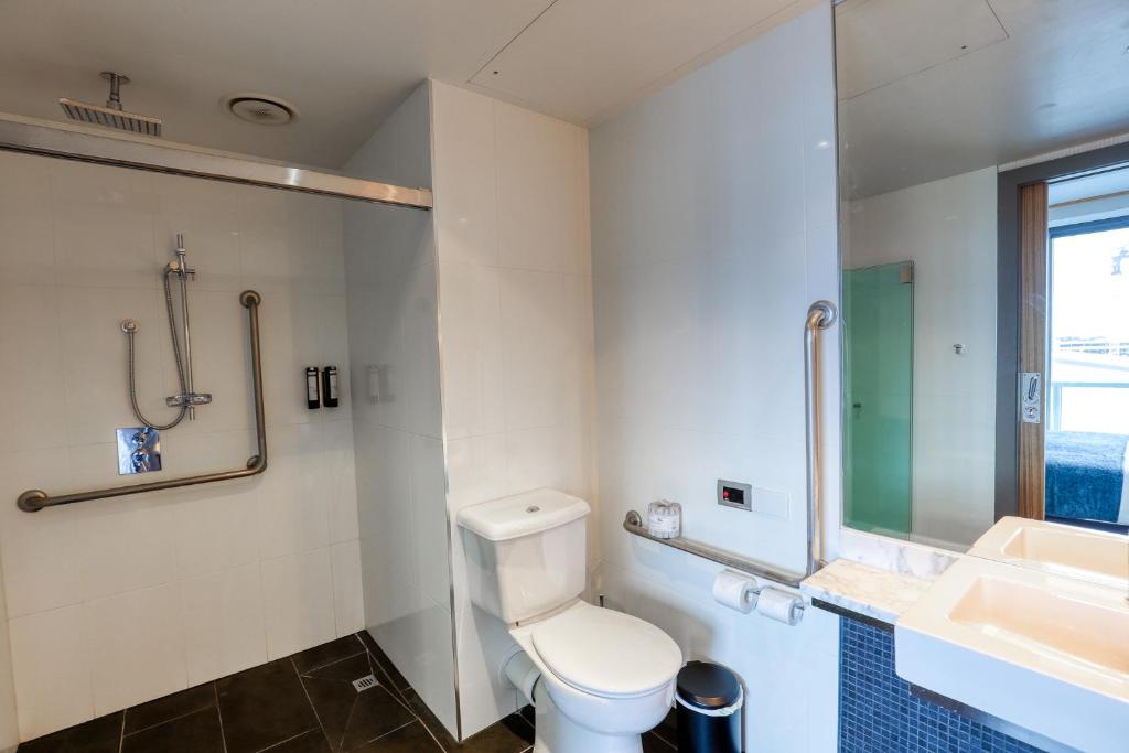 a bathroom with a toilet and a sink at Marsden Viaduct in Auckland