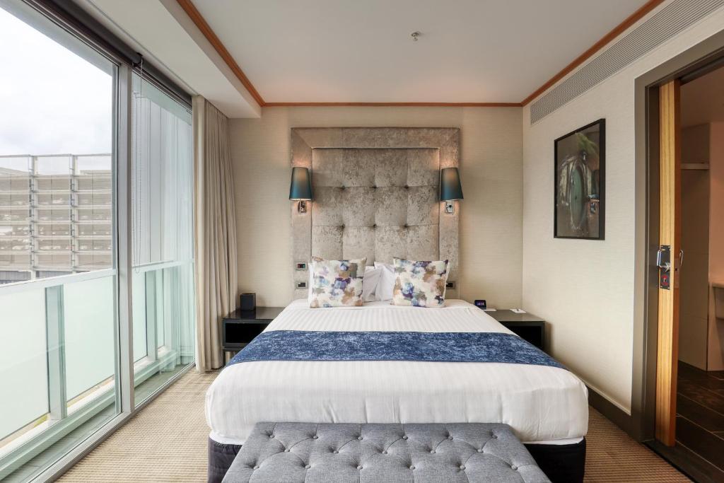 a bedroom with a large bed and a large window at Marsden Viaduct in Auckland