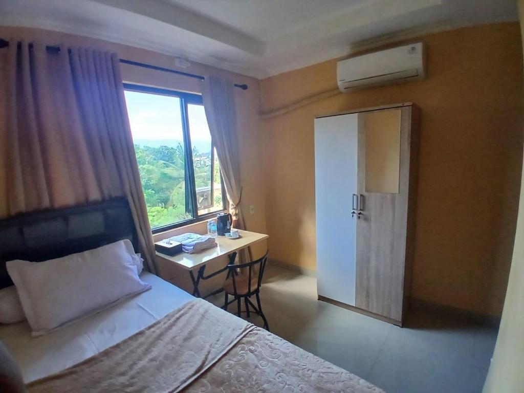 a bedroom with a bed and a desk and a window at Abaka hotel in Lamglumpang