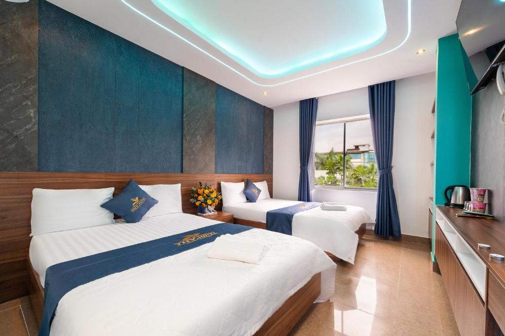 due letti in una stanza con pareti blu di Khách Sạn Tân Hoàng Yến ad Ho Chi Minh