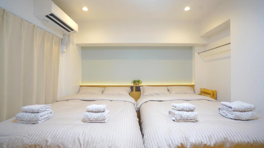 deux lits dans une chambre avec des serviettes dessus dans l'établissement Yuina Hotel Shinjuku, à Tokyo