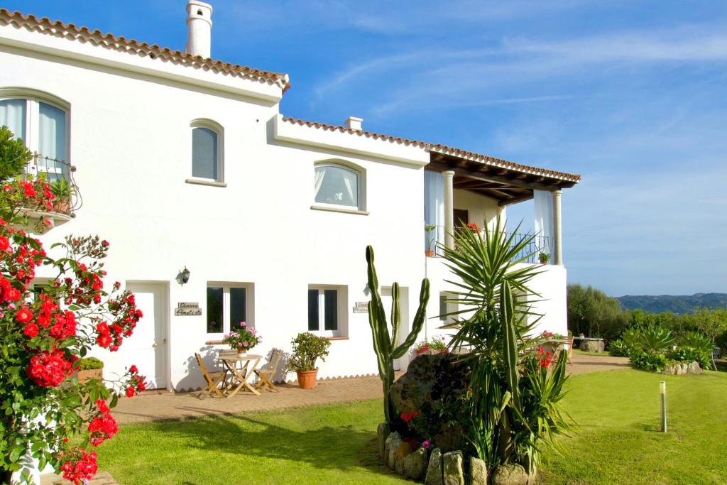 una vista exterior de una casa blanca con flores en La Dimora di Amaranta, en Baja Sardinia