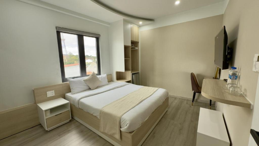 una camera da letto con un letto grande e una finestra di Hoang Thang 1 Hotel Da Lat City a Da Lat